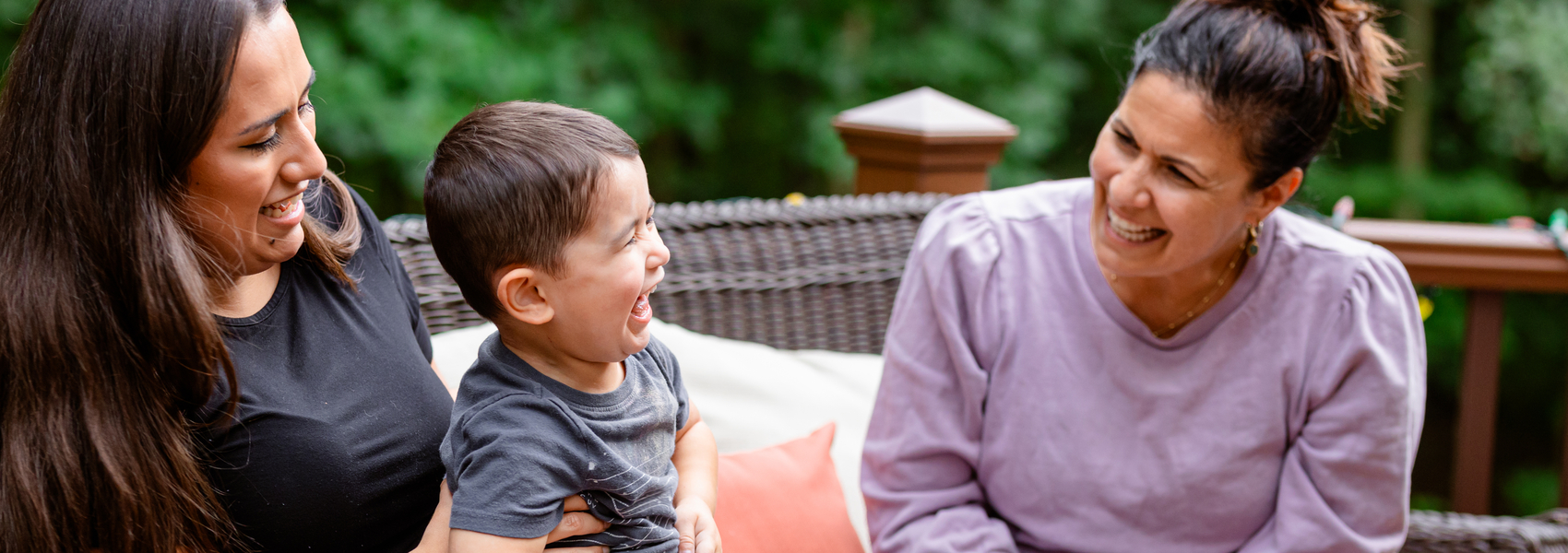 A mom holds her young son while visiting with a Safe Families host